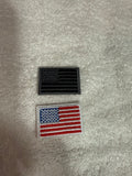 Two American flag patches on a textured gray background